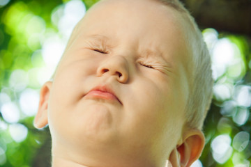 The little boy the kid squeezed his eyes and does not want to see anything. The child refuses to comply with the request.