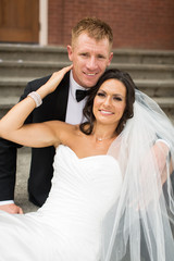 Beautiful bride and groom posing for camera on steps