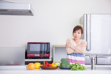 キッチンで寒がる女性