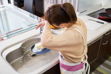 食器を洗う疲れた女性