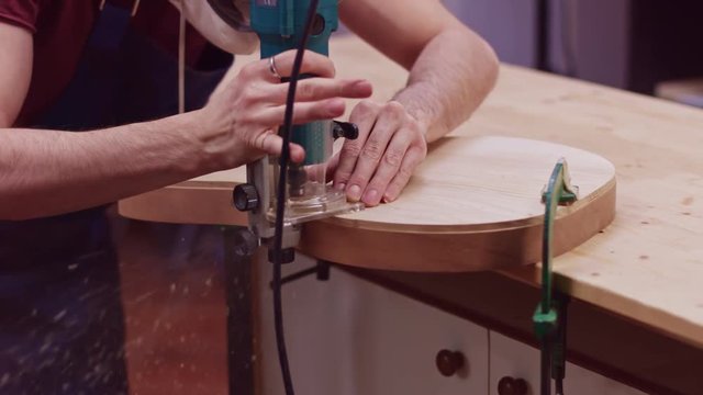 Guitar maker shapes wooden guitar body