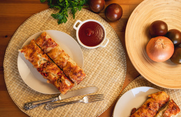 Homemade oven-baked focaccia bread with tomatoes, tomato sauce and parsley on a plate, ready-to-eat