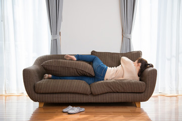 ソファでゴロゴロする女性