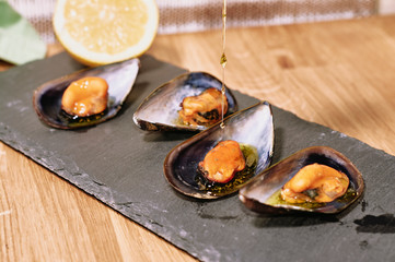 Steamed mussels on slate table and wooden table