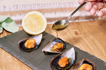 Steamed mussels on slate table and wooden table