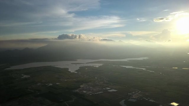 Gorgeous high altitude aerial shot of the sun high in the sky looking over the scenery below.
