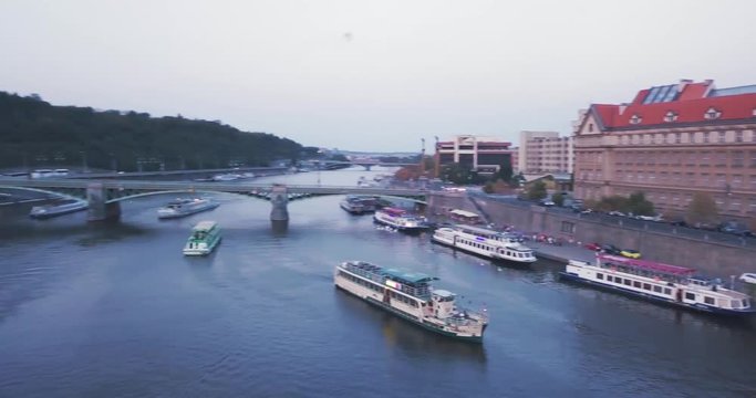 Aerial drone Moving to the Left revealing the Vltava River with boats and bridges around  in the city of Prage, Czech Republic