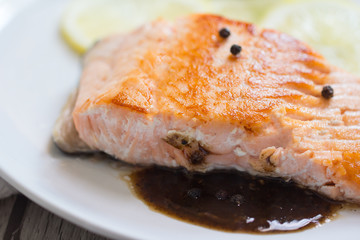 Grilled salmon steak with lemon and herb.