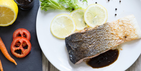 Grilled salmon steak with lemon and herb.