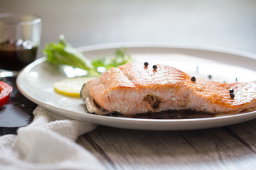 Grilled salmon steak with lemon and herb.