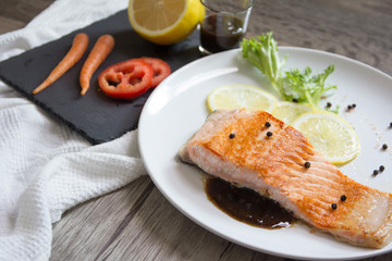 Grilled salmon steak with lemon and herb.