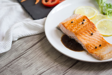 Grilled salmon steak with lemon and herb.