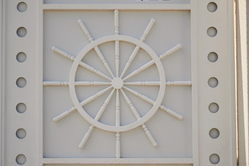 A chariot wheel carved into white wall. sculpture on the wall