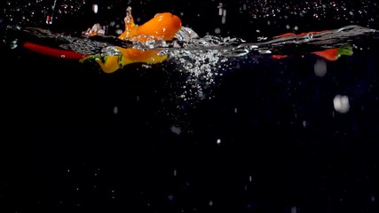 Vibrant orange sweet pepper being dropped into water in slow motion. - Powered by Adobe