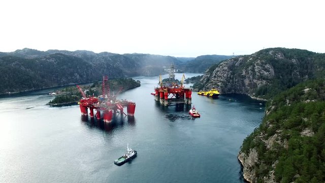 Offshore oil platforms in layup between mountains.