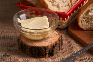 Butter and bread for breakfast, over rustic wooden background with copy space. Morning breakfast with butter and bread.