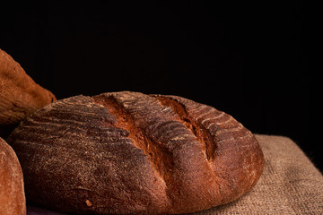 Bakery - gold rustic crusty loaves of bread and buns on black chalkboard background. Still life captured from above