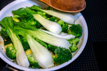 Cabbage and broccoli stew in pan on an electric stove