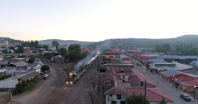 Aerial rolling drone shot of the El Chepe passenger train in Creel, Chihuahua, Mexico