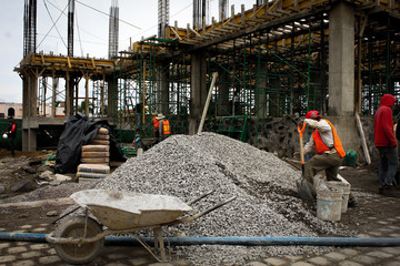 Trabajadores en construcción paleando grava