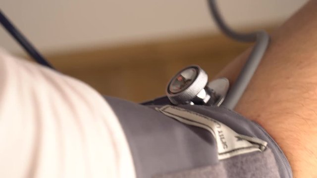 Aneroid Sphygmomanometer blood pressure equipment strap on a hand, close up shot