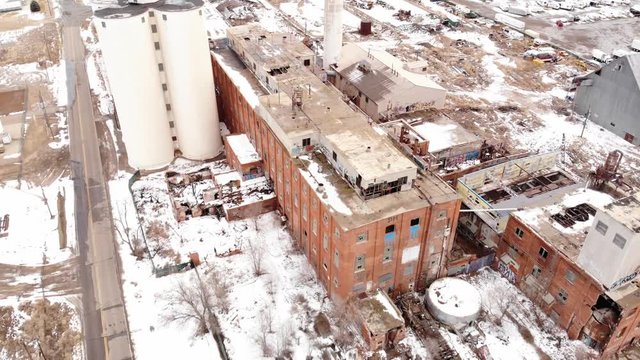 Aerial descending view of a big abandoned factory with red bricks.