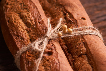 Two Fresh baguettes on dark wooden table. Selective focus