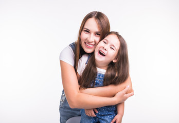Family, children and parenthood concept - Young woman with her little cute child on white background. Mom with daughter isolated.
