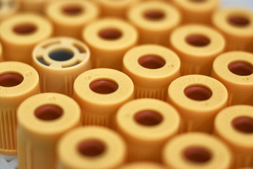 macro of test tubes with yellow top, against a gradient of white background. Concept of good health