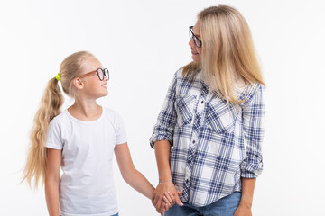 Happy young mother and laughing kid in fashion glasses have fun on white background