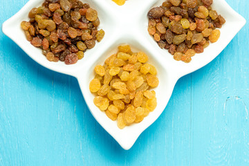 golden and brown raisins on plate. Top view of dried grapes.