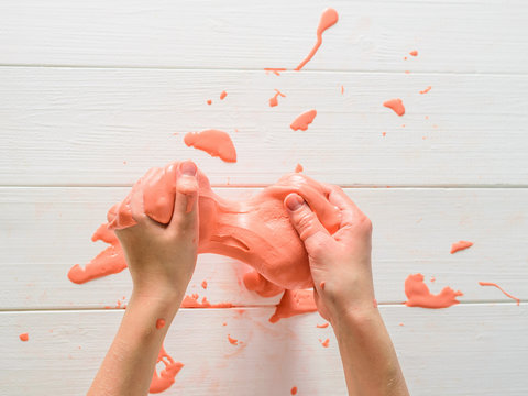 Baby pink slime smears on the white table.