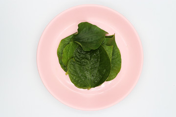 Chaplo leaves in pink dish on white background.