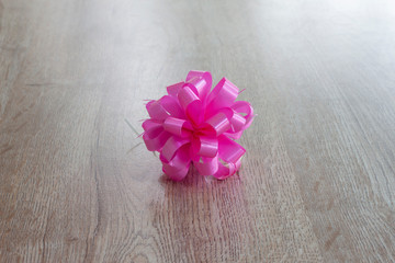 Fold the ribbon as a flower for decoration on wooden background.