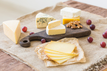 Various types of cheese, blue cheese and brie with grapes and nuts