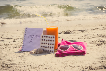 Medical pills, carrot juice and accessories for sunbathing, vitamin A and beautiful, lasting tan