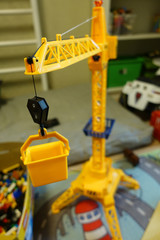 Yellow toy tower crane in the children's playroom.