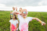 Holi festival, holidays and happiness concept - young teens and women in colors have fun outdoor