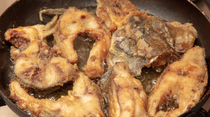 Fish is fried in a frying pan
