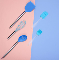 Kitchen utensils set : culinary brush, whisk, spatula on pastel background. Top view, minimalism