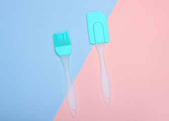 Kitchen pastry silicone set (spatula and brush) on pink blue pastel background. Top view, minimalism.