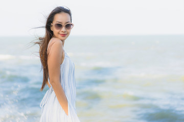 Fototapeta na wymiar Portrait beautiful young asian woman happy smile relax around neary beach and sea