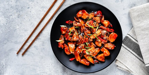 spicy chicken in sweet and sour sauce with chili pepper. teriyaki chicken's  with  sesame seeds. Chinese cuisine, Thai cuisine. Japanese food, copy space, recipe background, food flat lay