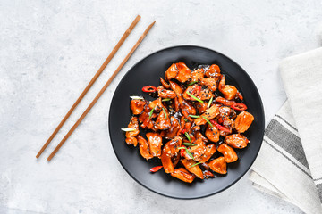 spicy chicken in sweet and sour sauce with chili pepper. teriyaki chicken's  with  sesame seeds. Chinese cuisine, Thai cuisine. Japanese food, copy space, recipe background, food flat lay © KEA