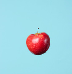 Ripe red apple on a blue background.