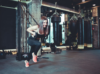 Fit woman doing exercise with strap at gym, workout, functional training. Sports lifestyle