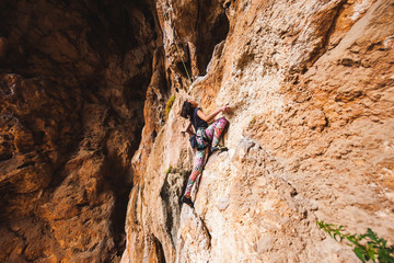A girl climbs a rock.