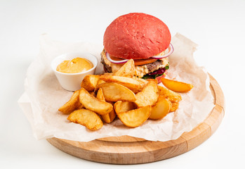 red burger with roasted potatoes and sauce