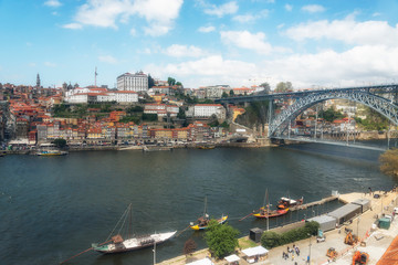 Fototapeta na wymiar Ancient boats on Douro River. Dom Luis Bridge. Porto, Portugal.
