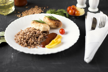 Chicken cutlets with buckwheat, herbs, ketchup and tomatoes